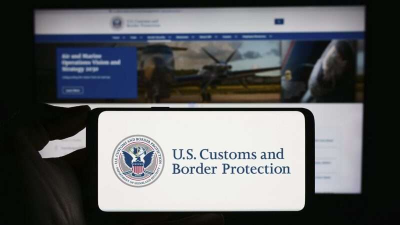Person holding mobile phone with seal of agency United States Customs and Border Protection (CBP) in front of web page. | imageBROKER/Timon Schneider/Newscom