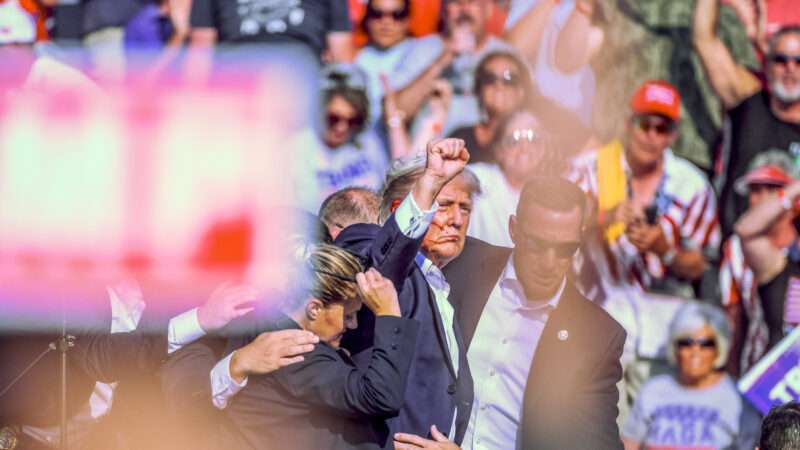 Former President Donald Trump holds up a fist as Secret Service agents escort him offstage, after an assassin tried to shoot him during a rally in Butler, Pennsylvania. | Morgan Phillips/Polaris/Newscom