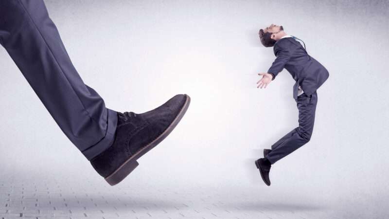 Man in business suit being kicked by a giant foot. | Ratz Attila | Dreamstime.com 