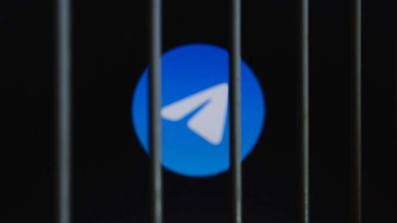 Telegram Messenger logo is displayed on a screen behind bars. | Andre M. Chang/ZUMAPRESS/Newscom