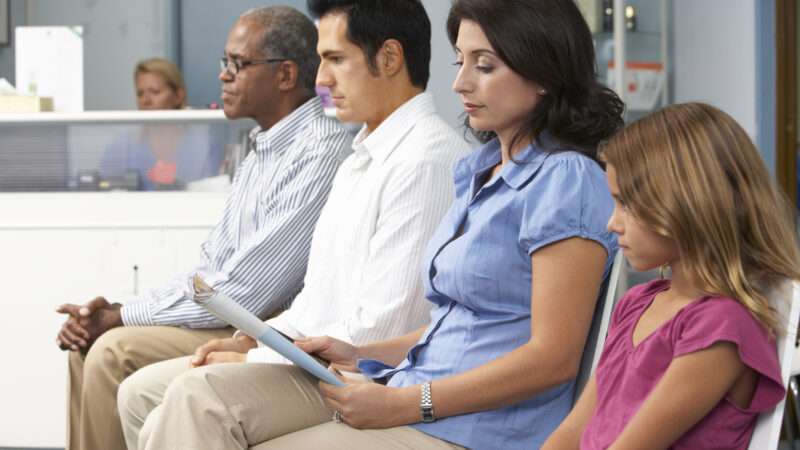 Seated patients in a row in a doctor's office waiting room. | Monkey Business Images | Dreamstime.com