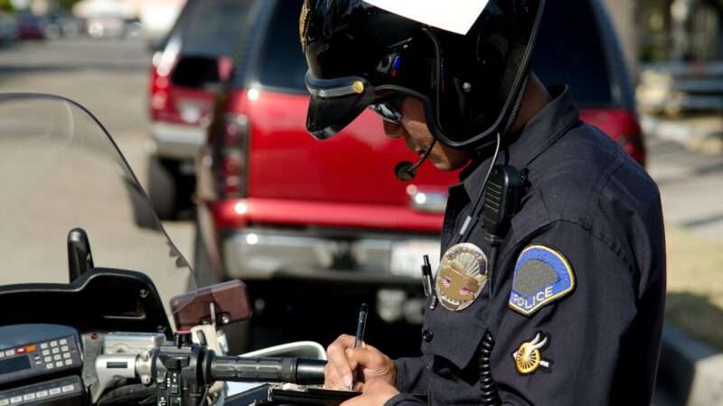 Police officer writes speeding ticket. | John Roman | Dreamstime.com 