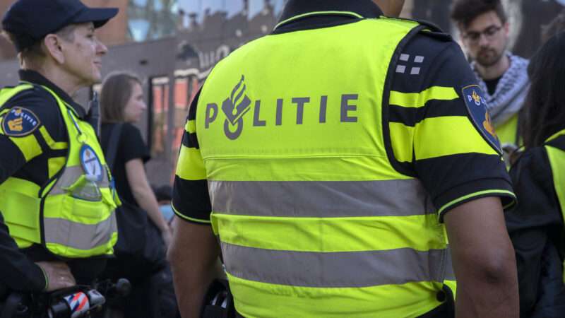 Officers in the Netherlands National Police Corps (Politie), wearing neon vests that read "Politie" | Robert Van T Hoenderdaal | Dreamstime.com