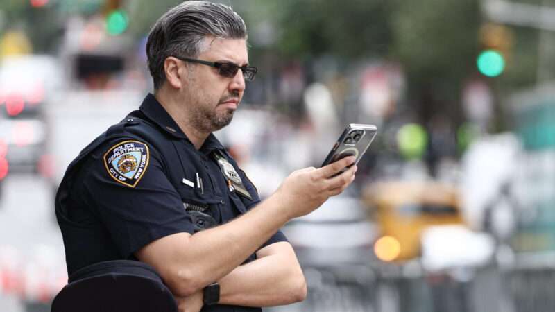 Police officer using a cell phone | Valery Sharifulin/ZUMAPRESS/Newscom