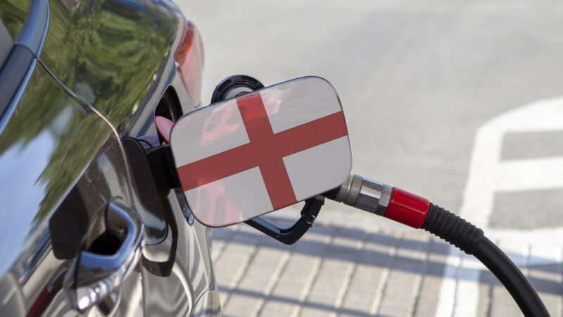 A gasoline nozzle fueling up a car with the Flag of England printed on the fuel door. | Andrey Kryukov | Dreamstime.com