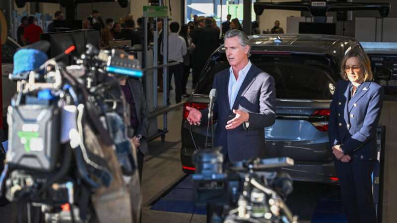 California Governor Gavin Newsom stands in front of an electric vehicle and talks to reporters | CRAIG KOHLRUSS/TNS/Newscom