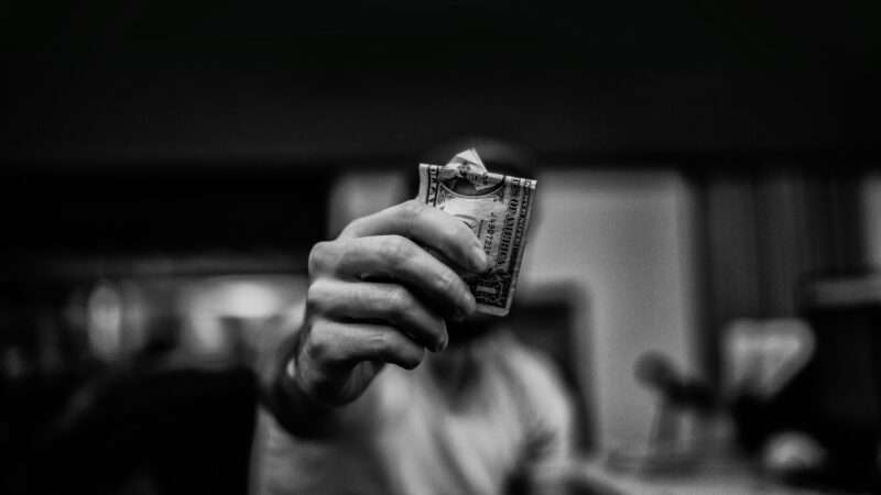 A person holding a dollar bill | Photo by lucas Favre on Unsplash