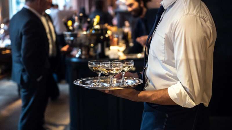 A waiter holds a tray of drinks | ID 114744889 © Mykyta Starychenko | Dreamstime.com