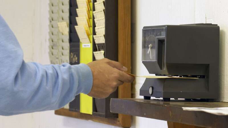 A worker's hand punches out on a time clock using a card. | Glen Jones | Dreamstime.com