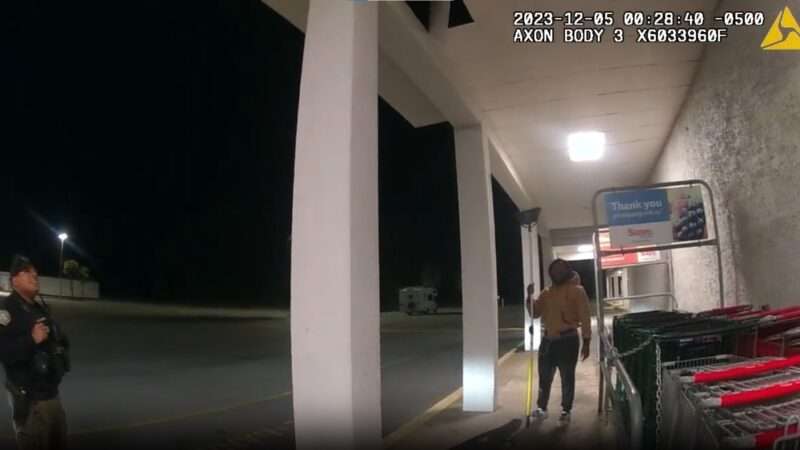 A screenshot from a video showing Glynn County police and David Smiley outside a store | Reason