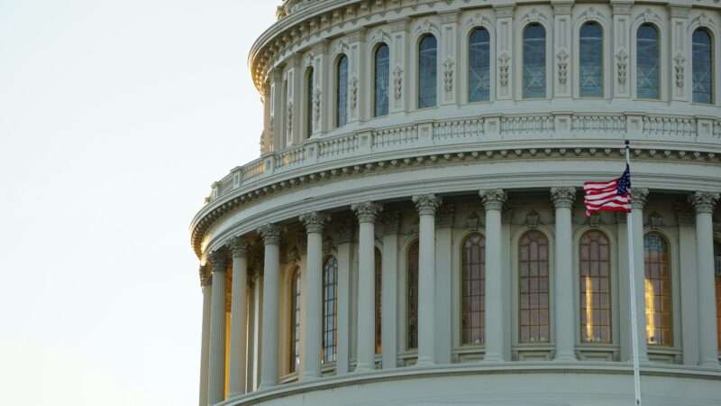 An American flag flies in front of the dome of the United States Capitol building | Photo by Ian Hutchinson on Unsplash