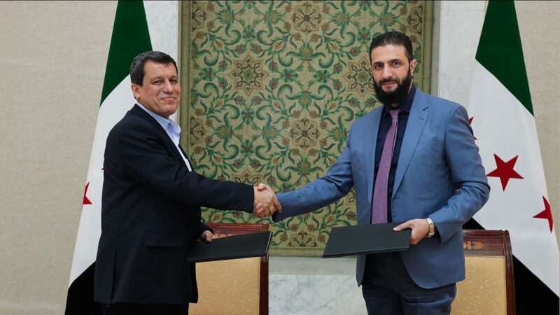 Syria's interim president Ahmed al-Sharaa shaking the hand of Syrian Democratic Forces (SDF) commander-in-chief Mazloum Abdi after the signing of an agreement in Damascus, Syria. March 10, 2025. | Syrian Arab News Agency (SANA)/UPI/Newscom