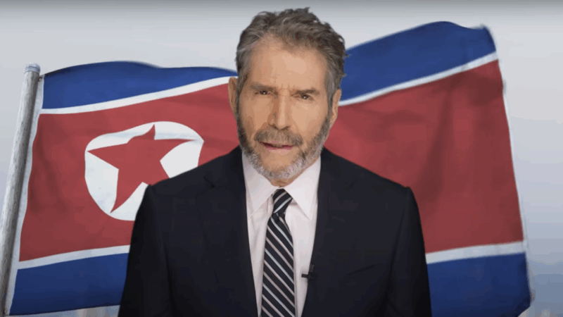 John Stossel stands in front of a North Korean flag | Stossel TV
