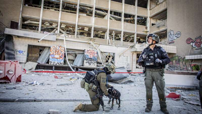 Israeli first responder and a police officer seen at a site of an Iranian ballistic missile strike in Haifa, Israel. June 16, 2025. | Eyal Warshavsky/ZUMA Press/Newscom