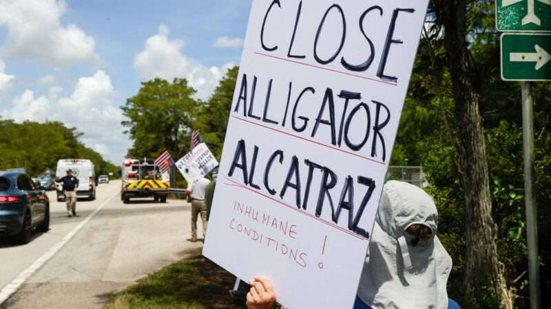 protester holding a sign outside alligator alcatraz | Luis Santana/ZUMA Press/Newscom