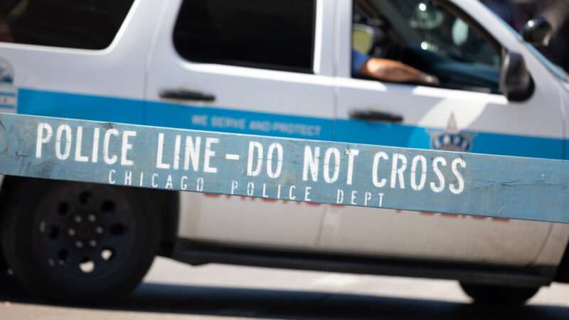 Chicago Police Department vehicle, with a wooden barrier that says "Police Line - Do Not Cross" in the foreground. | Roberto Galan | Dreamstime.com