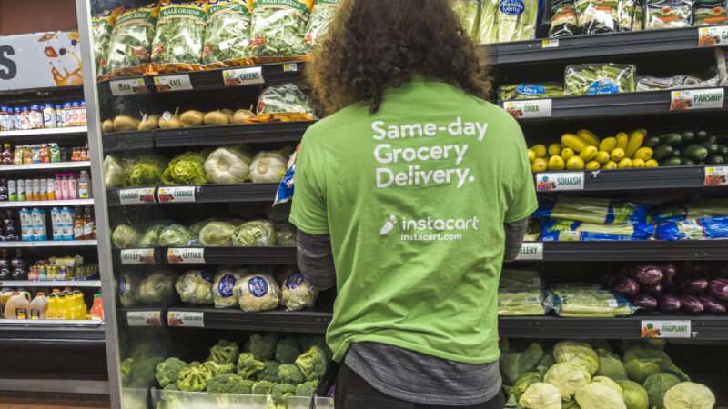 A person with a green shirt looks at a grocery store produce cooler | Richard B. Levine/Newscom