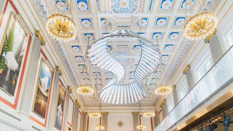 A bright and ornate room with paintings, chandeliers, and fancy ceiling tiles | Milken Center for Advancing the American Dream