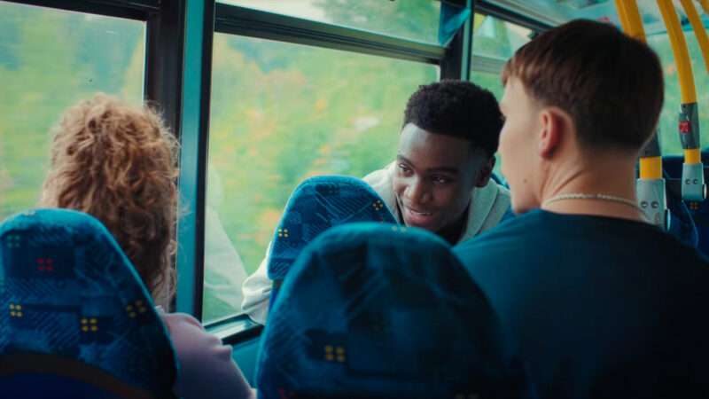 Students talk on a school bus, in an image from an ad. | Transport for London/Youtube
