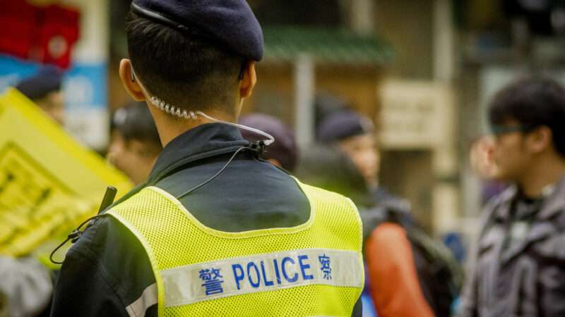 A Hong Kong police officer wears a neon vest. | imageBROKER/mt KANG/Newscom