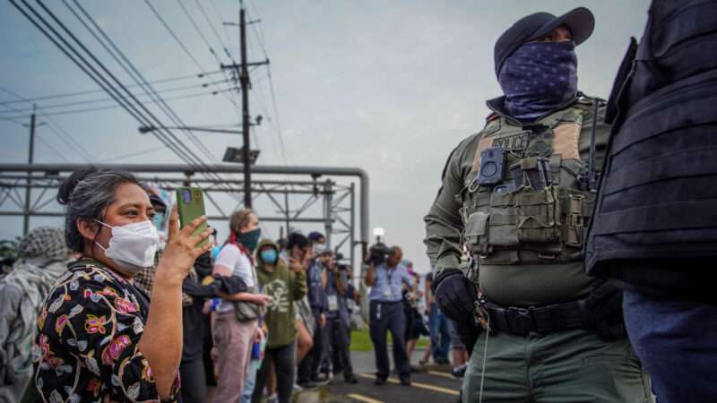 A protester records immigration agents | Derek French/SOPA Images/Sipa USA/Newscom