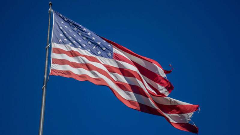 An American flag waves on a flagpole. | Gregor Doerr/Dreamstime