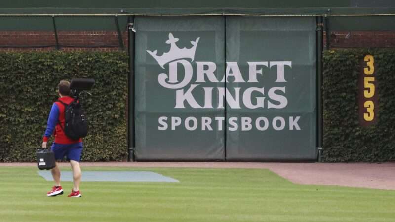 A logo for "DraftKings Sportsbook" is pictured on the outfield wall of Wrigley Field, surrounded by ivy. | John J. Kim/TNS/Newscom