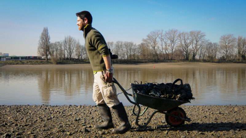 A volunteer pulls a cart as he helps clean the River Thames. | Stephen Simpson/Photoshot/Newscom