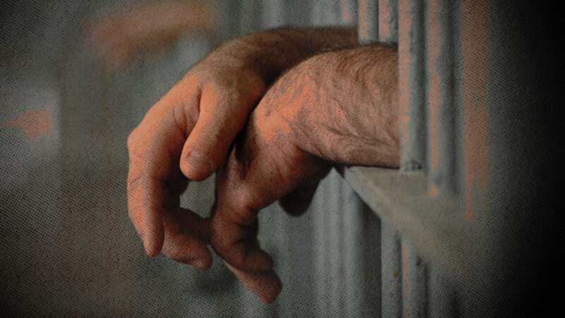Hands of a prisoner behind bars | Photo: Willeecole/Dreamstime