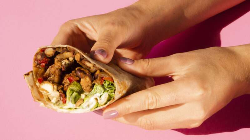 A pair of hands holding a burrito | pantherphotos12646976 (RF)