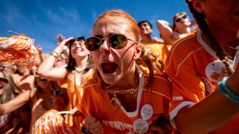 A section of Tennessee fans in orange are cheering, with a focus on one woman in sunglasses who is shouting and had dyed her hair orange. | Photo: Camden Hall/ZUMAPRESS/Newscom