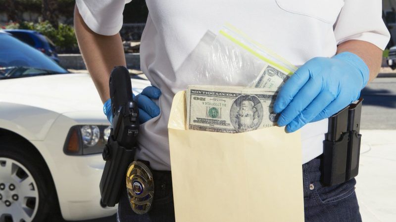 cop holding money | Dreamstime.com