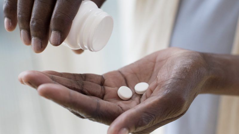 Pills being shaken out of the bottle into someone's hand | Science Photo Library/Newscom