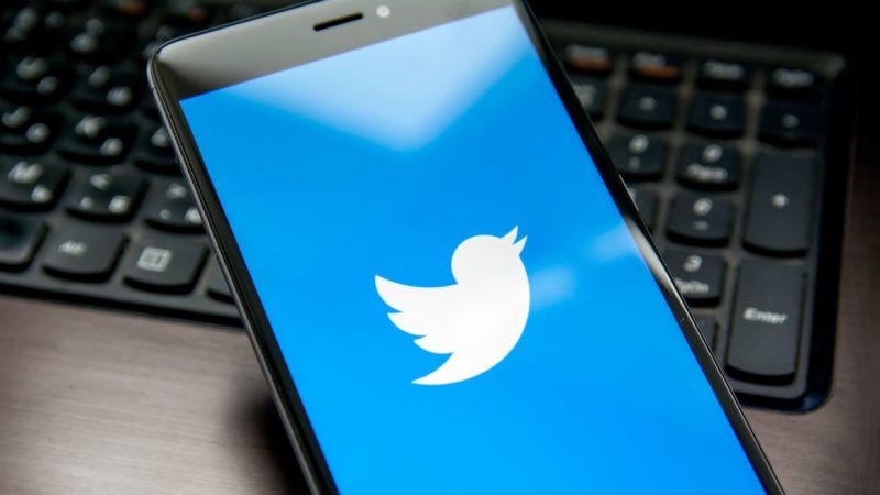 Image of a Twitter logo on a smartphone, which is sitting on a laptop keyboard. | Pavel Starikov/Dreamstime.com