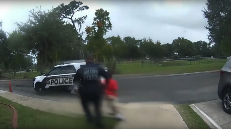 police officer leading a small child away in handcuffs | YouTube
