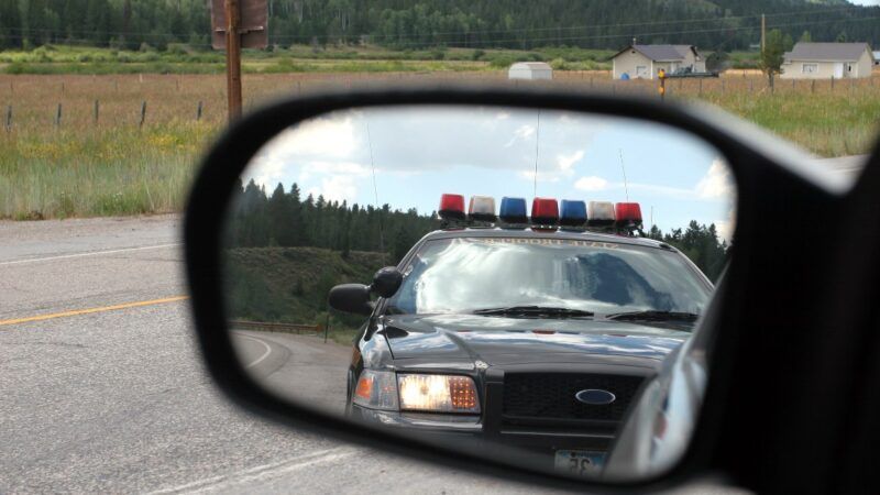 A police car shown through a side-view mirror