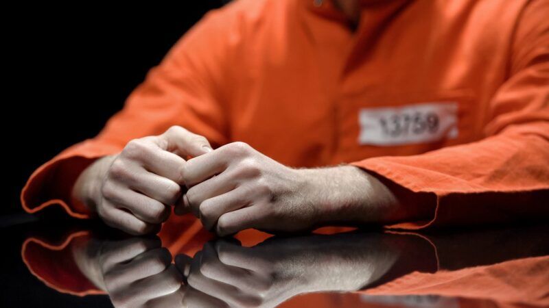 a person wearing an orange prison jumpsuit