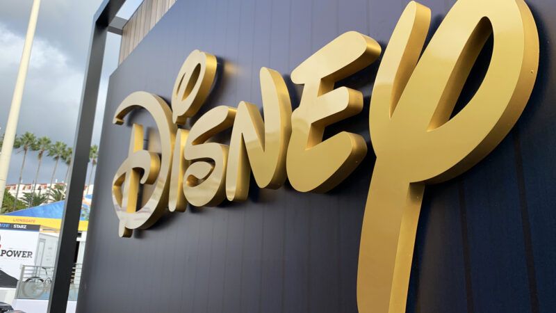 Gold Disney logo on a black background shot from a side angle