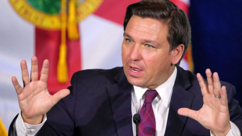 Ron DeSantis speaks in front of the Florida flag