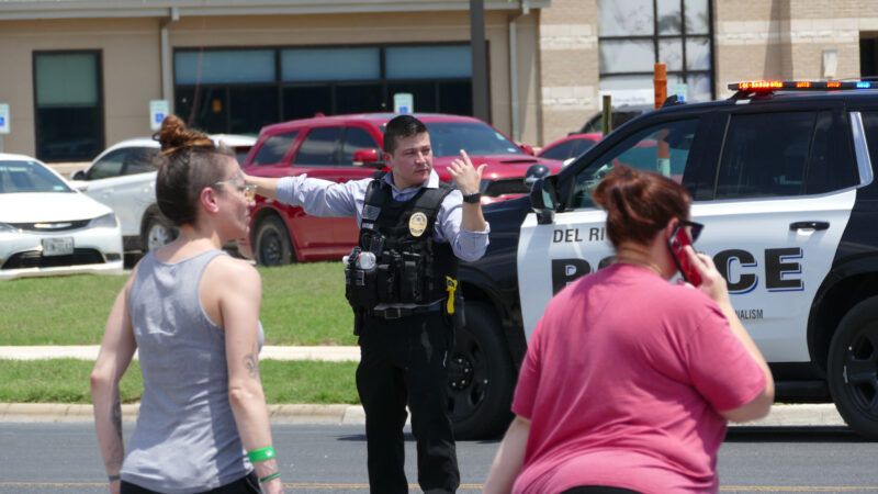 Police officer directs traffic and pedestrians. | Billy Calzada/Zuma Press/Newscom