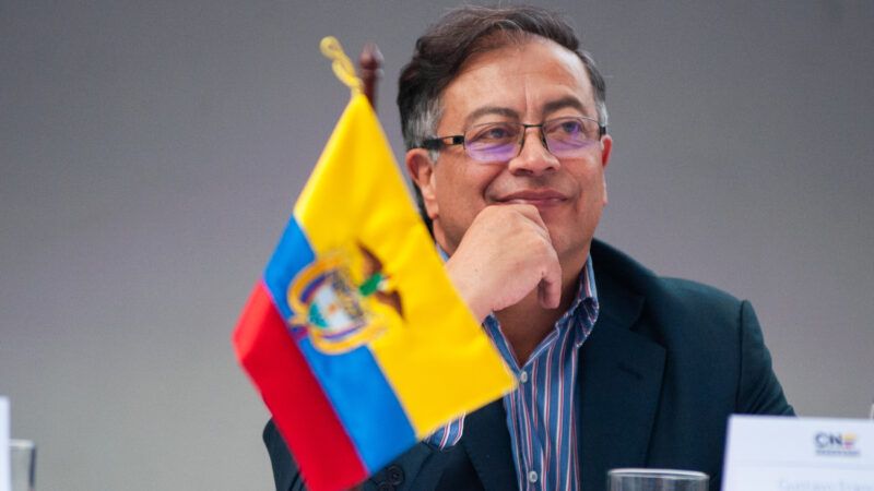 President-Elect of Colombia Petro smiling in front of a flag