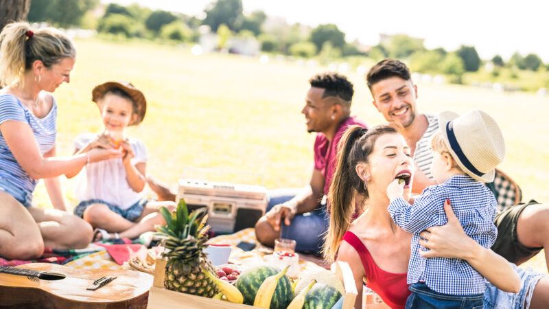 A family with parents and children sitting at a picnic outside | Photo 139999318 © Mirko Vitali | Dreamstime.com