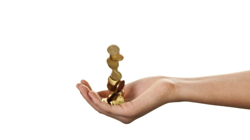 Studio image of someone dropping coins from one hand to the other.