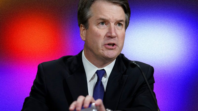 Justice Brett Kavanaugh flanked by police lights