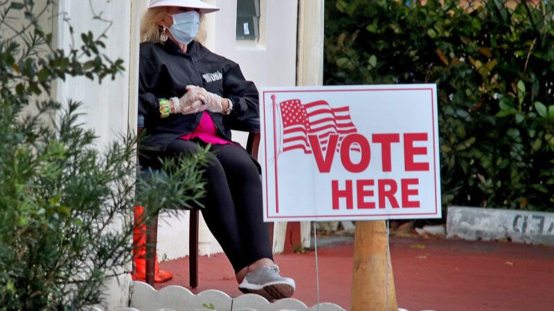a poll worker sitting outside of a voting place | Susan Stocker/TNS/Newscom