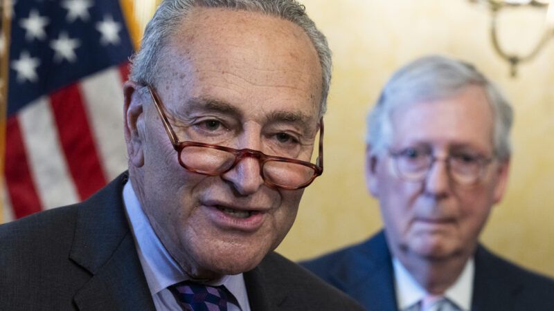 Senator Chuck Schumer speaking while Senator Mitch McConnell watches in the background. | Tom Williams/CQ Roll Call/Newscom