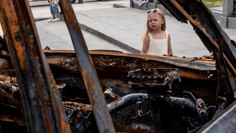 Little girl looking through empty windshield of burned out car in Ukraine. | Dominika Zarzycka/Sipa USA/Newscom