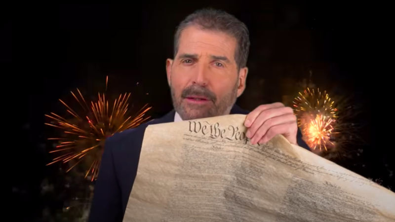John Stossel holding up a copy of the US Constitution