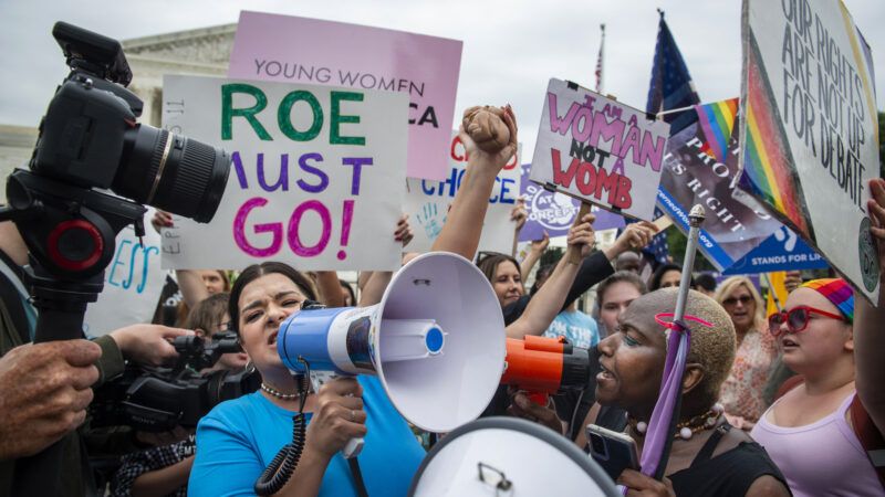 Women is yelling into a speakerphone to protest abortion