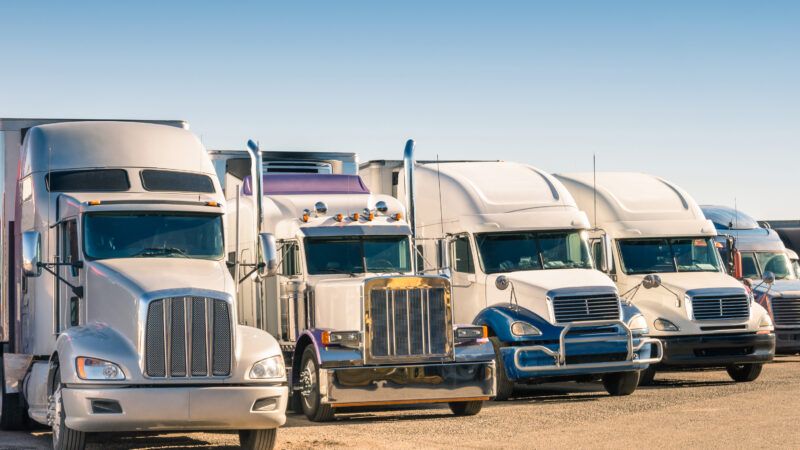 Long-haul trucks idling at a truck stop | Mirko Vitali | Dreamstime.com